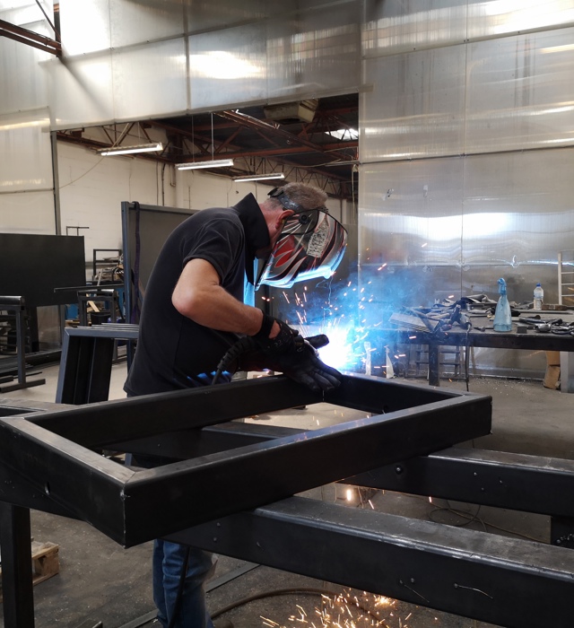 Fabricator welding steel frame at Abbey Group