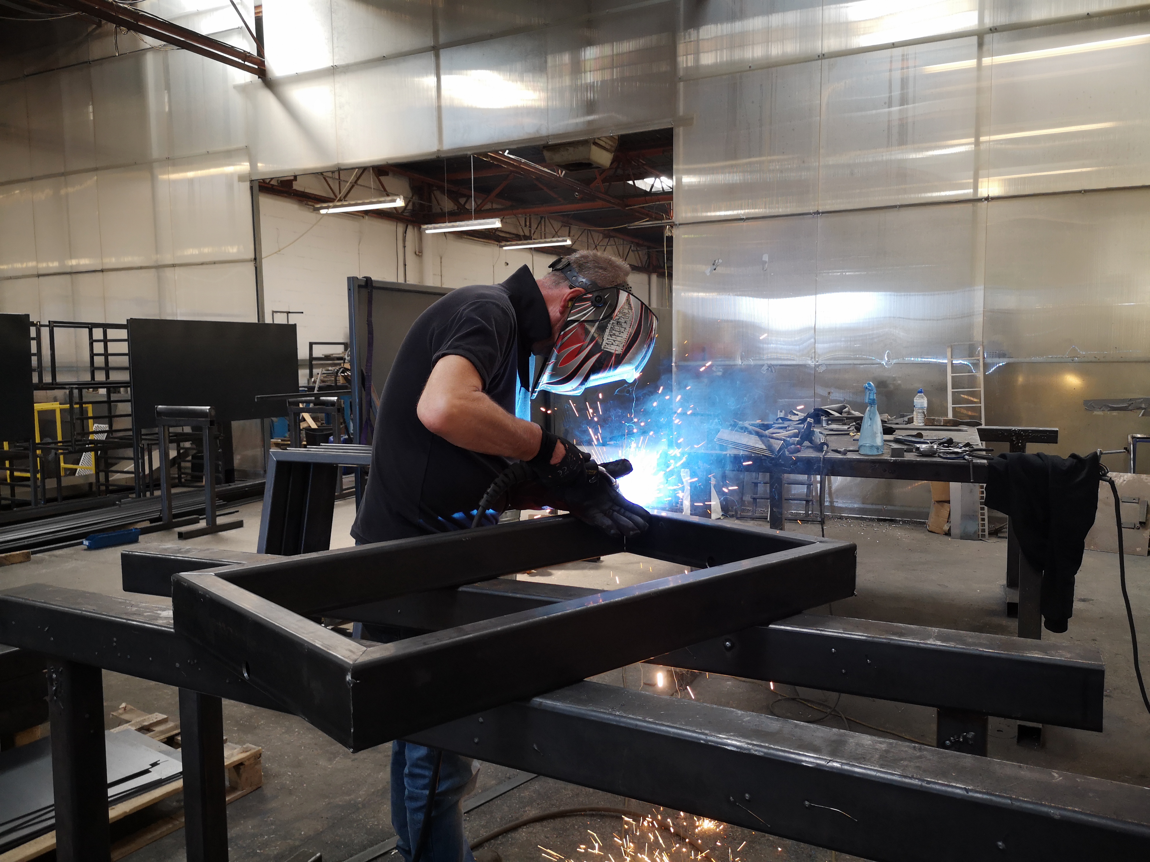Fabricator welding steel frame at Abbey Group