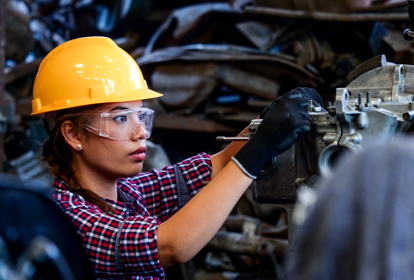 Female Engineer working with machine in factory.