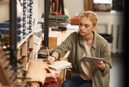 A female manufacturer inside a workshop checking inventory