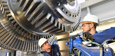 workers assembling and constructing gas turbines in a modern industrial factory