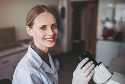 Experienced female scientist is working in laboratory. Doing investigations with microscope.