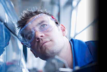 Male mechanic inspecting the side panel of a vehicle