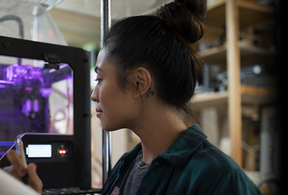 Female engineer observing 3D printer in operation