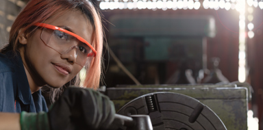 Certified industry female mechanical engineer working on industrial factory machinery - Skilled apprentice technician woman wearing safety equipment