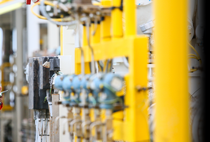 An engineer inspecting pipework inside an industrial factory