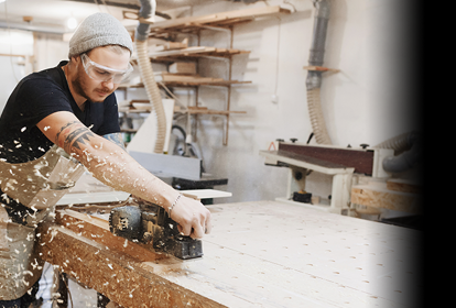 Male joinery worker cutting sheet of wood